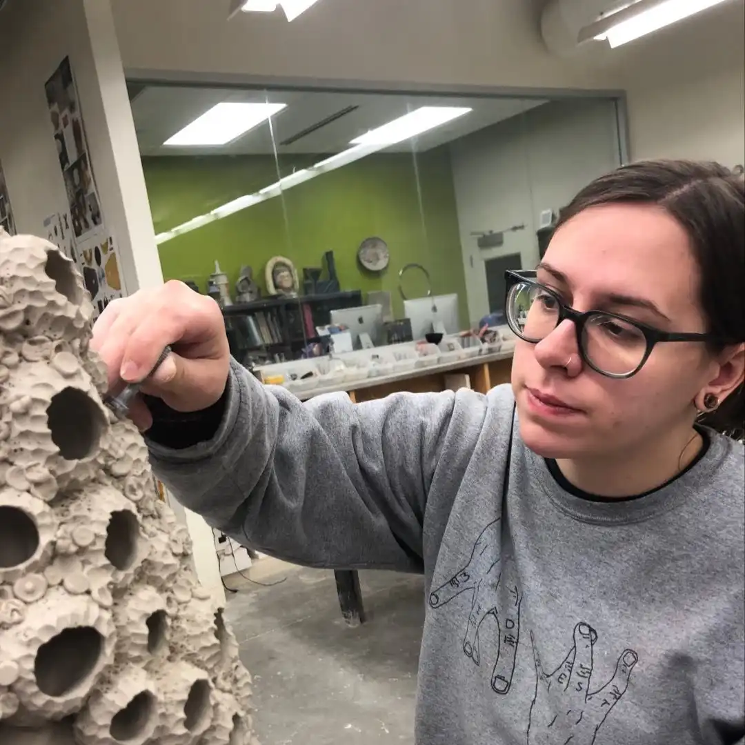 Featured Artist: Tori Miener⁠
This body of work is an exploration of organic forms, both functional and sculptural. In each piece, the idea of the vessel becomes abstracted. The forms are less about functionality and more about the experience of interaction with the materials during the creative process. My interest in this relationship continues after the work is finished by enticing people to touch and handle the objects. These unusual forms of both natural and manmade materials are intended to capture biomorphism, a concept dominant in this series. This theme discusses memory, positive vs. negative, how those memories can alter or deteriorate over time, and how we relate to each other's memories. ⁠
In this body of work titled: “Reminiscence” my inspirations for these forms derive from landscapes I explored in East Asia, Sicily, the Midwest, and the deserts of Arizona. The textures consist largely of found objects discovered during my travels.These works, including the sculptures, are intended to be touched, handled and experienced,so as to intrigue not just the eyes but the hands as well. Textures are applied with special found objects; nuts, necklaces, shells, bolts, screws and more. These objects, now tools, are mementos that I encounter in my daily life, relics that have become a crucial part of the making process. Used as stamps: they are pressed, stabbed, or slashed into the clay to create a fossilized memory of the object, an echo of  one’s own consciousness and past impressions. ⁠
This unwavering interest in biomorphism has stirred those I’m close with to seek out found objects and contribute to my creative process. These donated collaborations become very significant for me personally and further drive home the warmth I seek to convey. This body of work is a realization of more than sharing a tangible form of my memories and experiences. My intent is to promote independent, unconventional thinking and to convey the value of nature, the rewards of spontaneity and the joys of rejecting the status quo. ⁠
